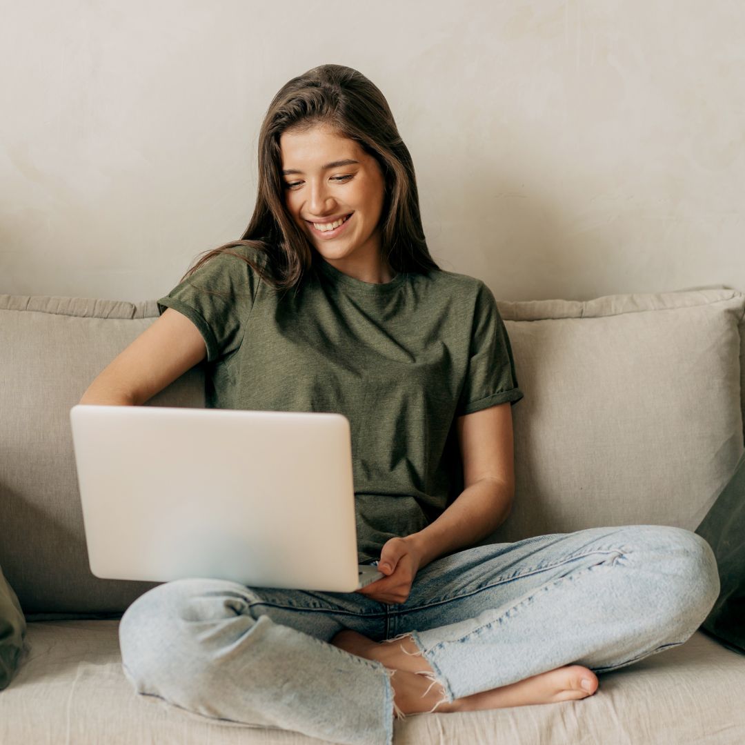 woman on her couch using laptop